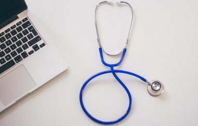 Metade de um Notebook e um estetoscópio azul