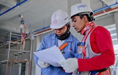 Dois profissionais com equipamentos de segurança em momento de trabalho