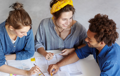 3 jovens em uma mesa de estudo para início das aulas
